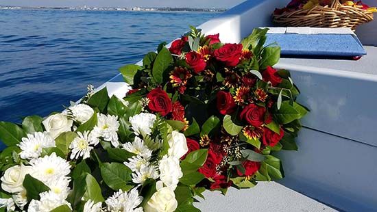Flower on boat with ocean in the background - getting ready for a burial at sea with cremains